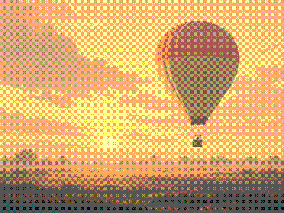 Painted hot-air balloon lifting off a misty field at golden sunrise.